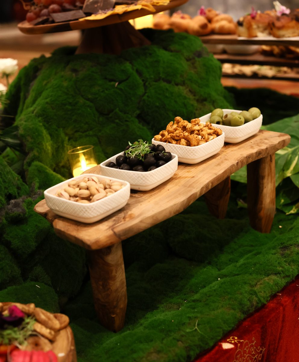 Moss-styled charcuterie base with pistachios, olives, marinated cashews
